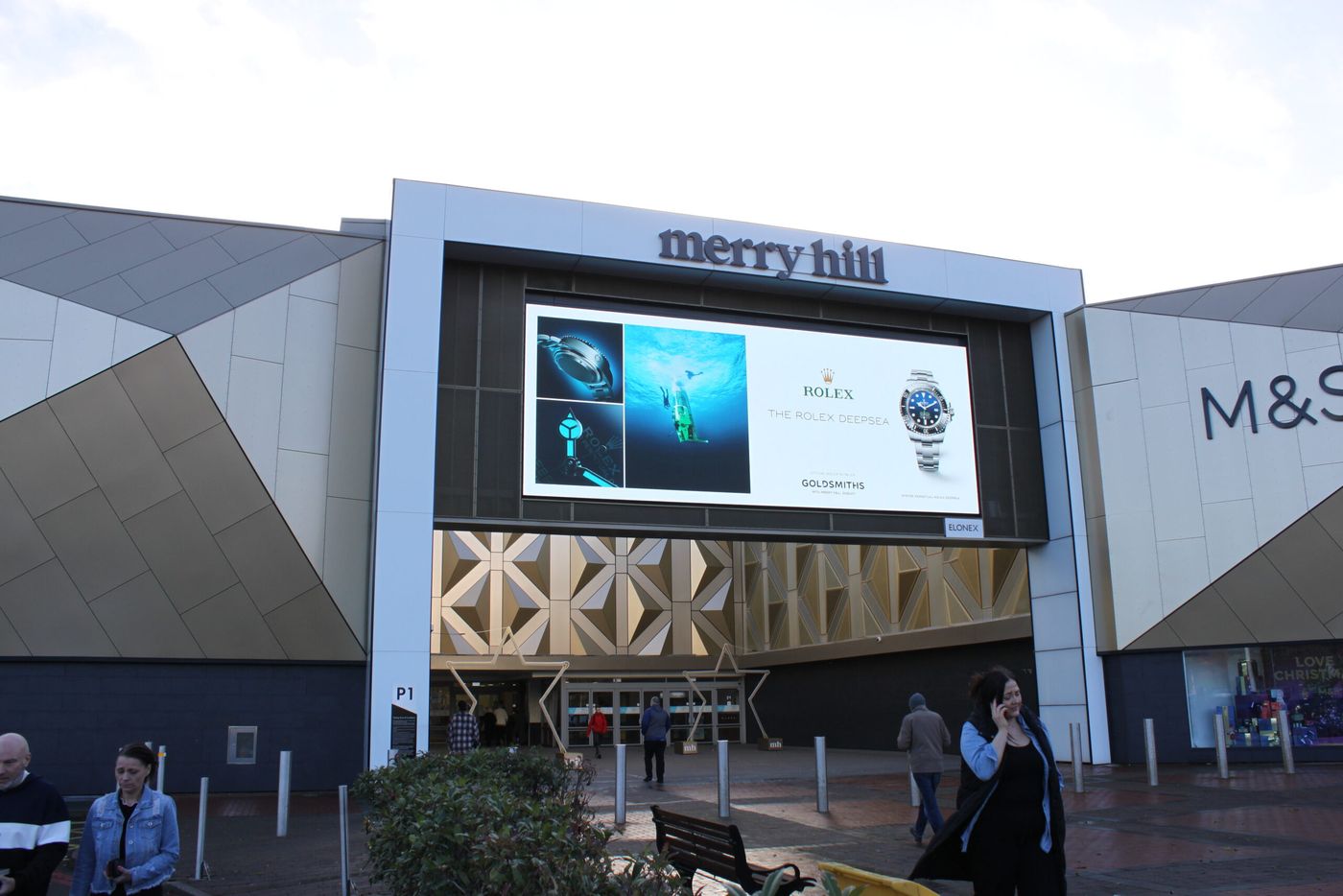 A large digital screen on the front of a shopping centre