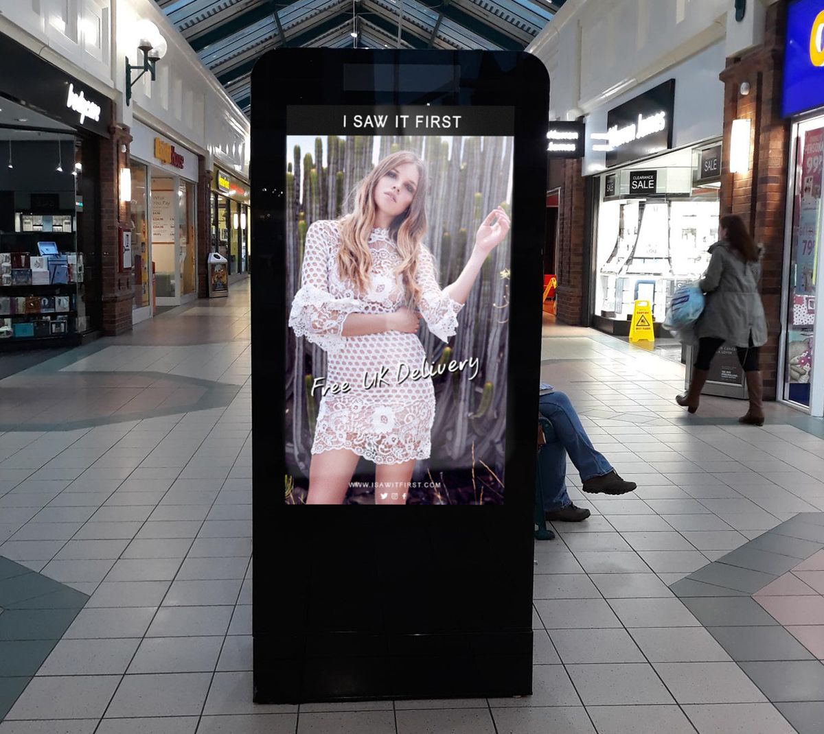 A digital fashion ad on a shopping centre screen