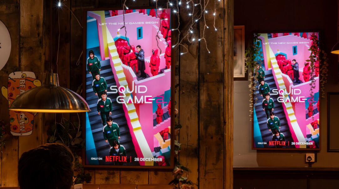 Digital screens showing an ad inside a pub