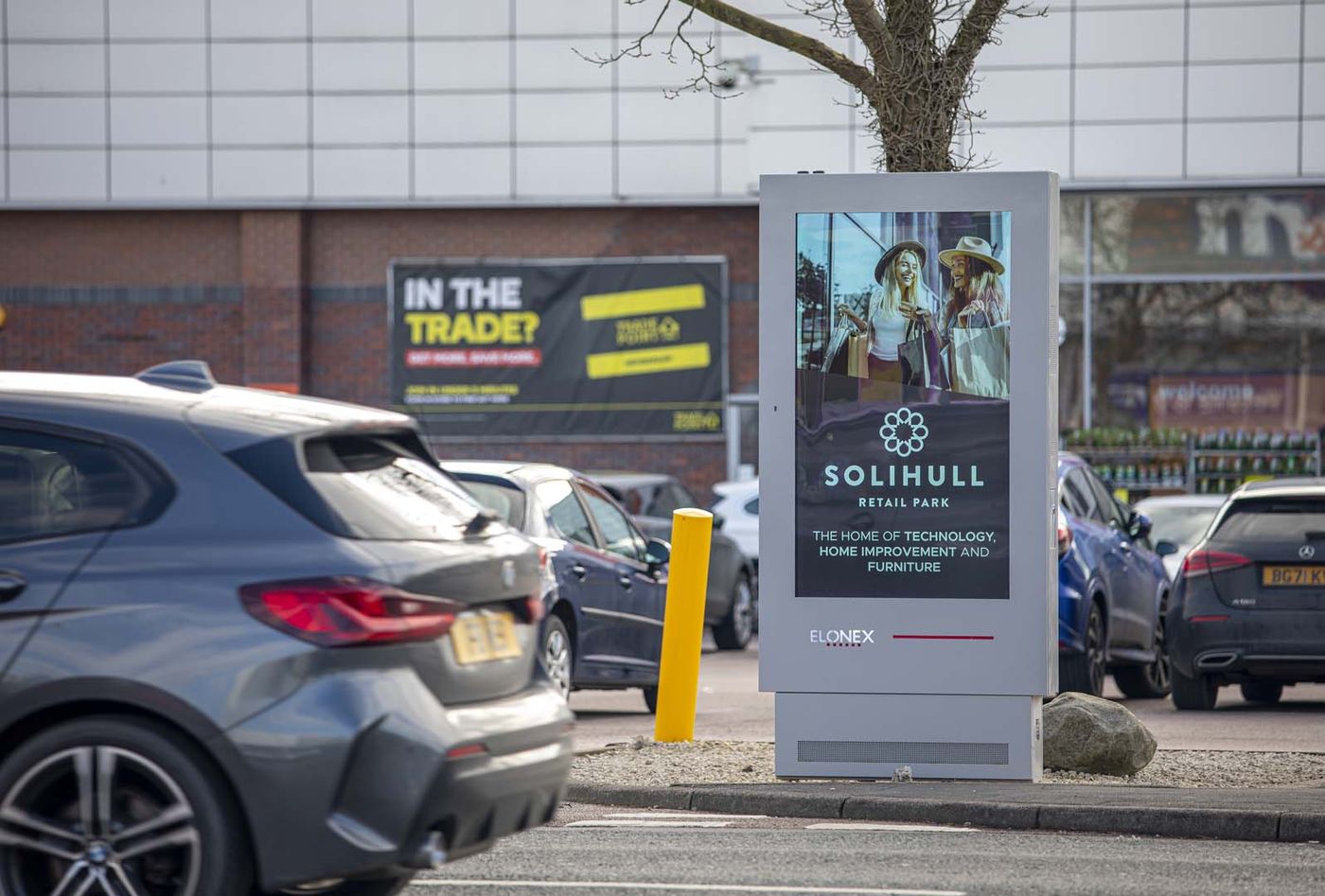 A digital totem screen in a retail park car park
